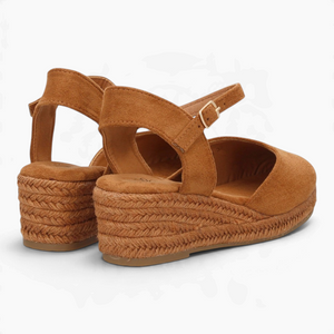 Alpargatas Nuxual de cuña baja en color camel con acabado de esparto, puntera cerrada y hebilla en el tobillo.