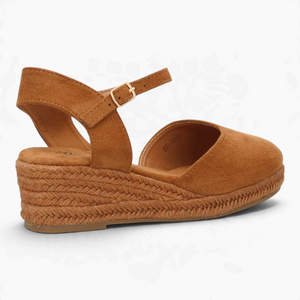 Alpargatas Nuxual de cuña baja en color camel con suela de esparto, puntera cerrada y correa con hebilla al tobillo.